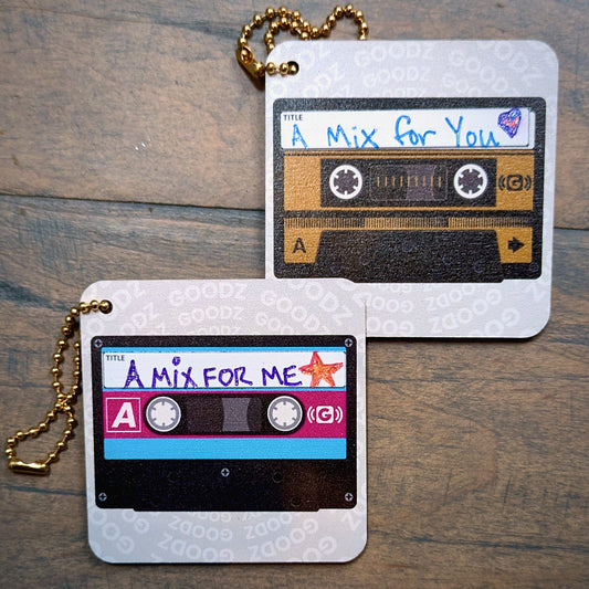 Two Mixtape Goodz on a wooden table, labeled A Mix for You and A Mix for Me, with gold ball chains